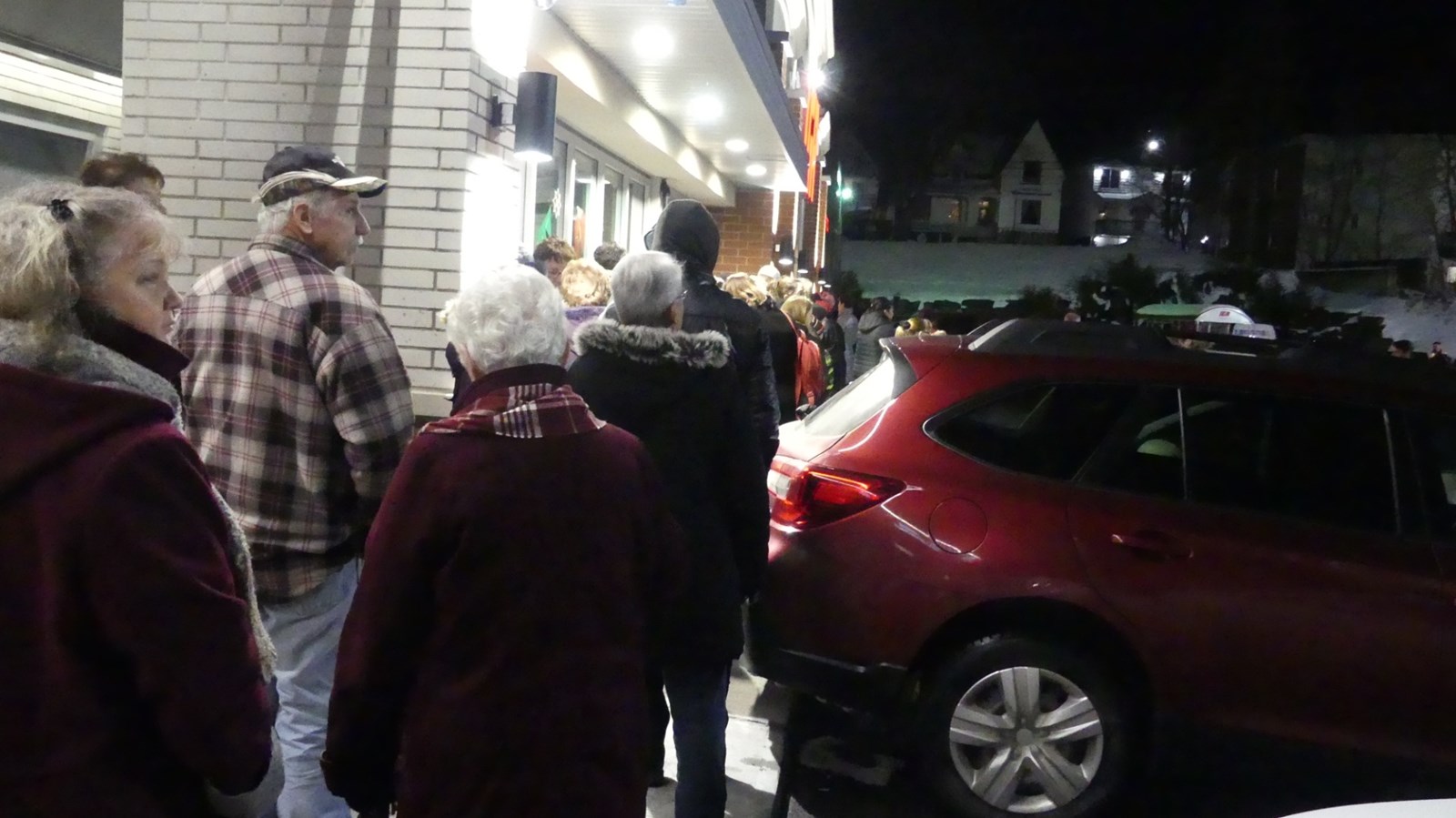 Dehors, les gens ont attendu en faisant une longue file.