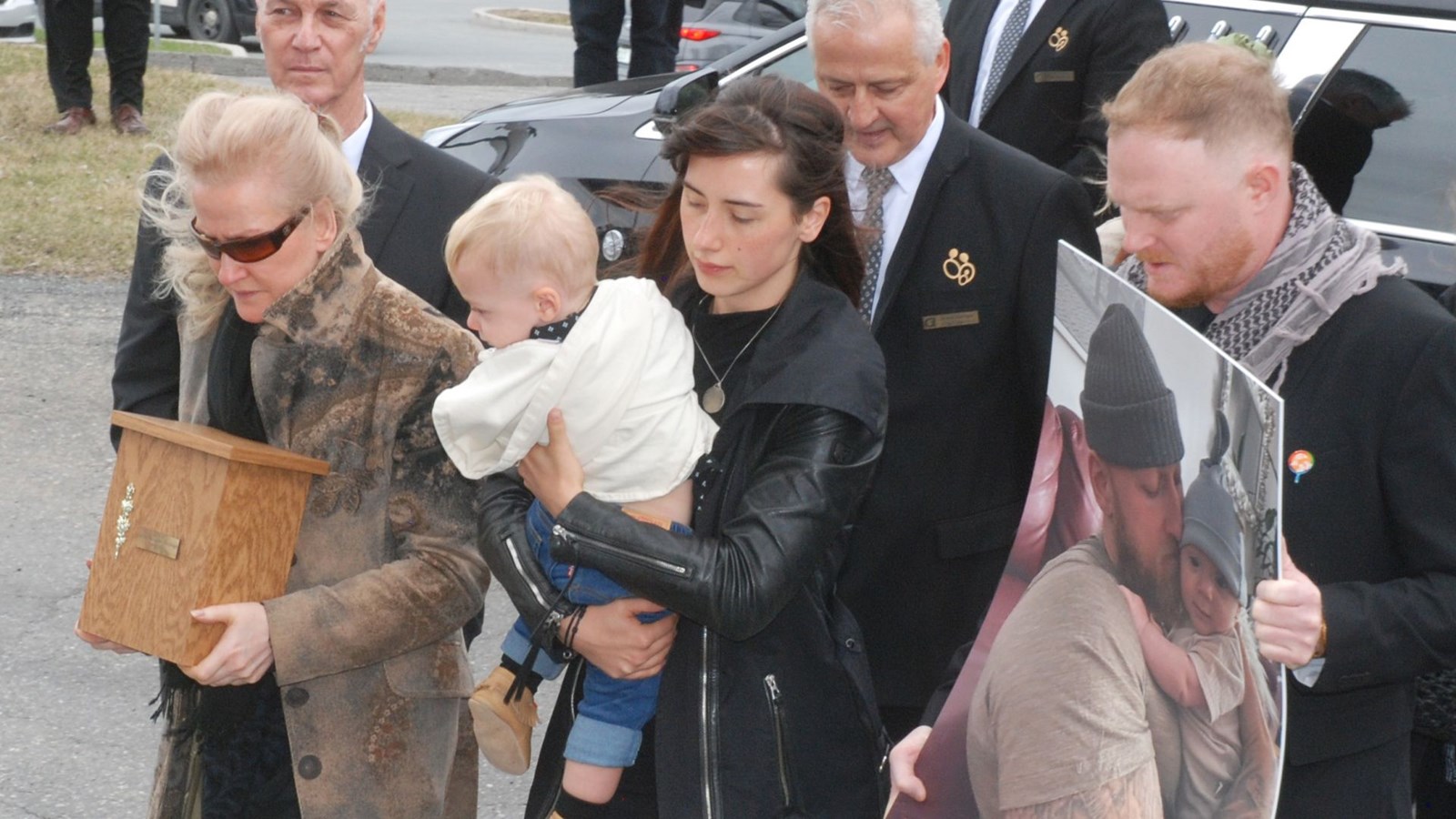 La mère de Jacob Flickinger, Sylvie Labrecque, portant l'urne funéraire en compagnie du fiston, Jasper, et de la conjointe, Sandy Leclerc, lors des funérailles en l'église de Saint-Georges le 19 avril 2024.