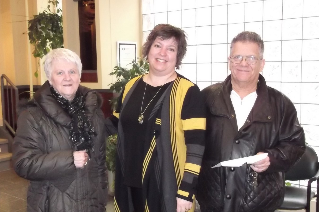 Mme Marie Caron et M. Gilbert Rivard, du Cercle culturel de l’amitié, entourant Mme Josée Fortin, directrice du financement à l’Association du cancer de l’Est du Québec, lors de la remise du chèque.