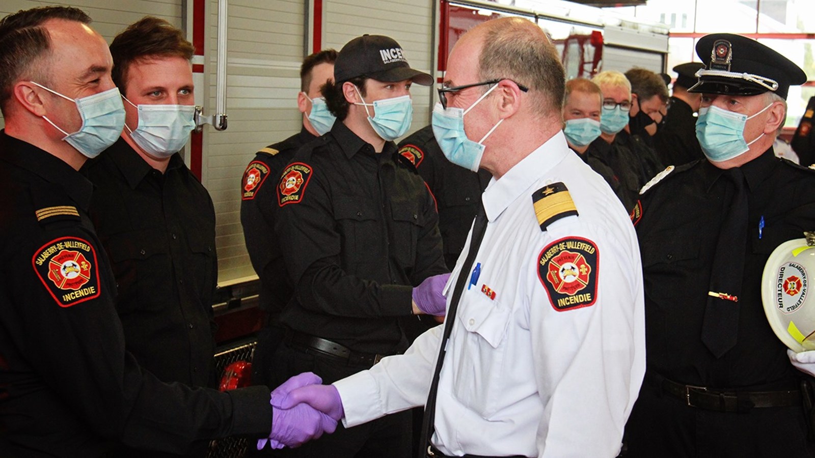 Avec gants et masques, M. Ménard a pris le temps de saluer chaque officier et pompier présent à la cérémonie de façon personnelle