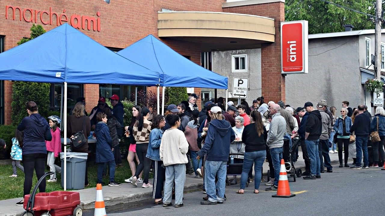 Residents gather outside the new Marché Ami grocery store in Ste. Anne de Bellevue yesterday evening for a barbecue to celebrate the arrival of new outlet which officially opened this morning.