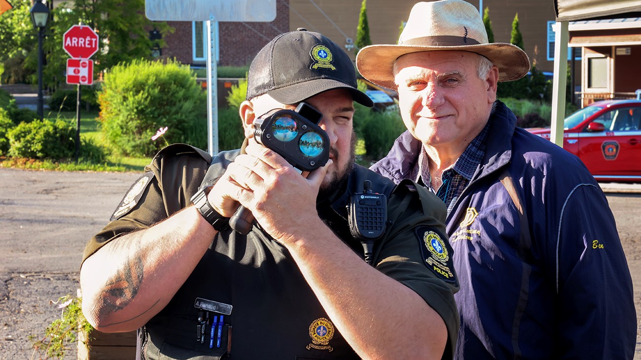 Un policier de la Sûreté du Québec utilise le radar avec le maire Bernard Daoust
