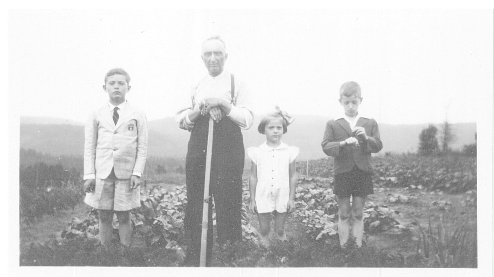 Les enfants en compagnie de leur père dans un champ. Vers 1949-50.