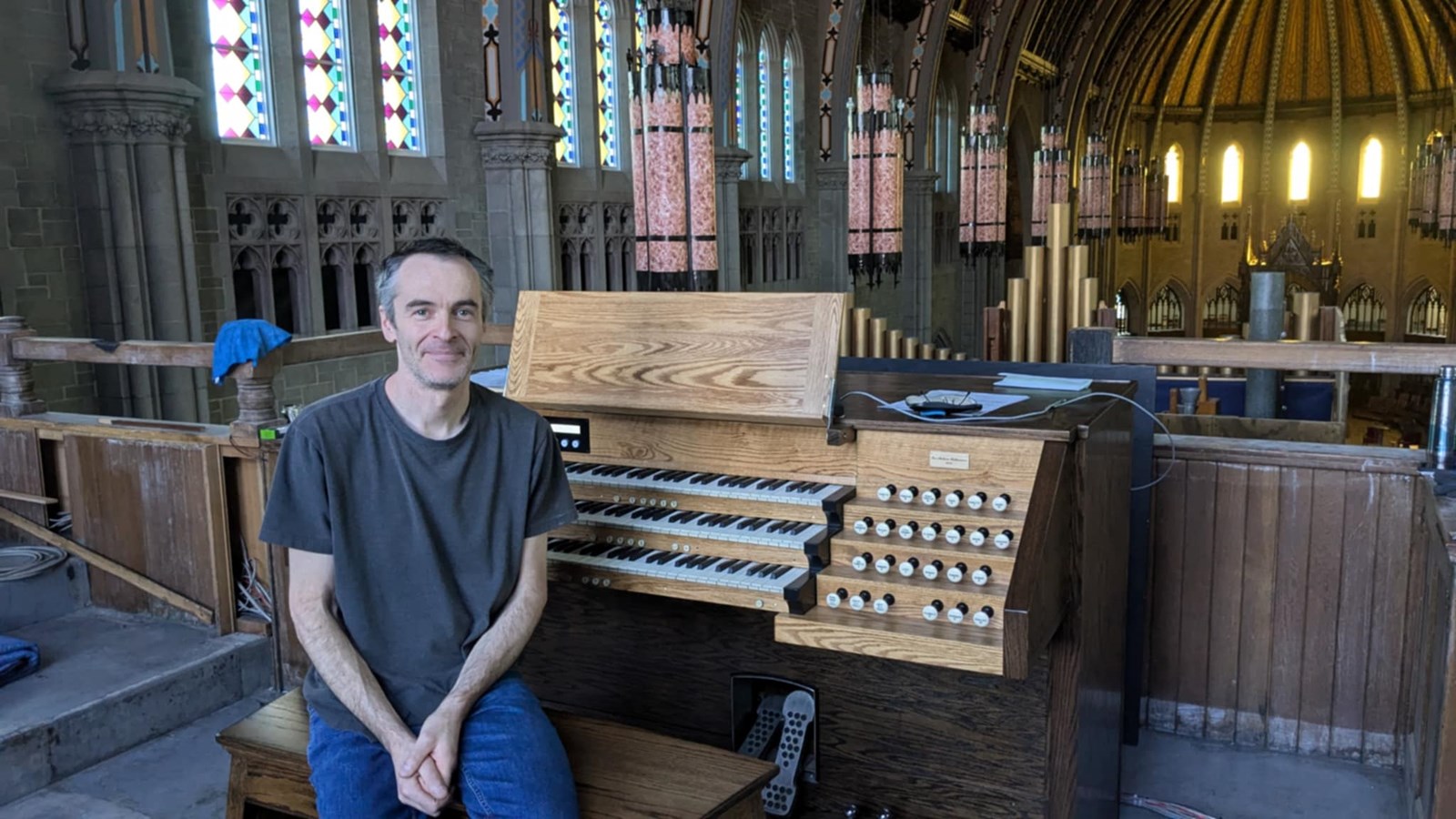 Jean-Sébastien Dufour, des Ateliers Bellavance, pose devant l'instrument qu'il a restauré au cours des deux dernières années