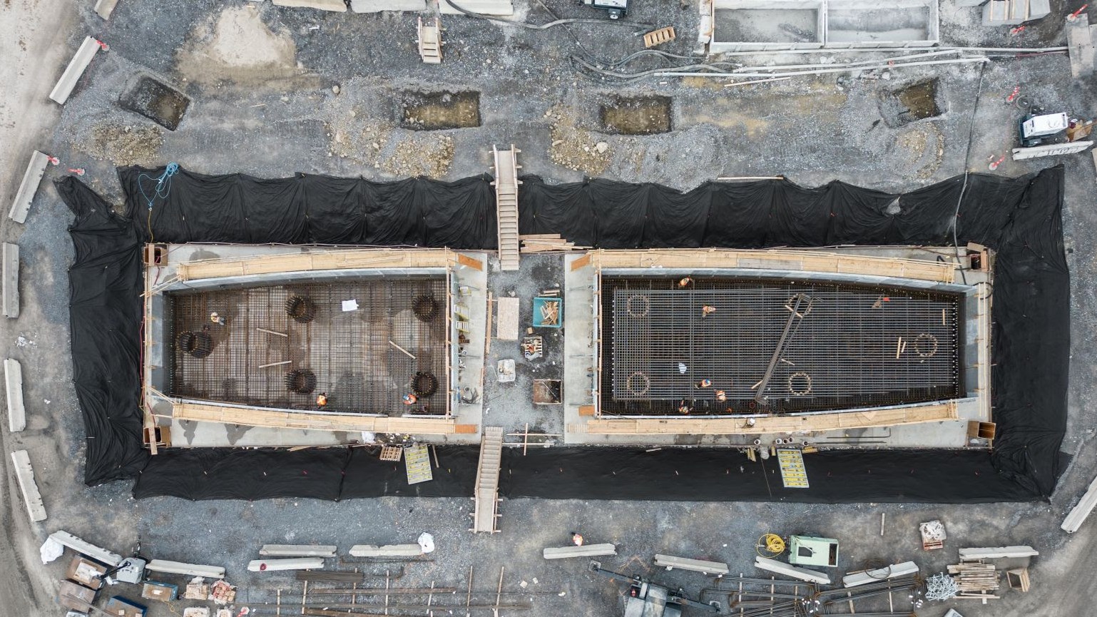 Des travailleurs en train de poser l’armature d’acier dans les semelles d’une pile, mai 2024.