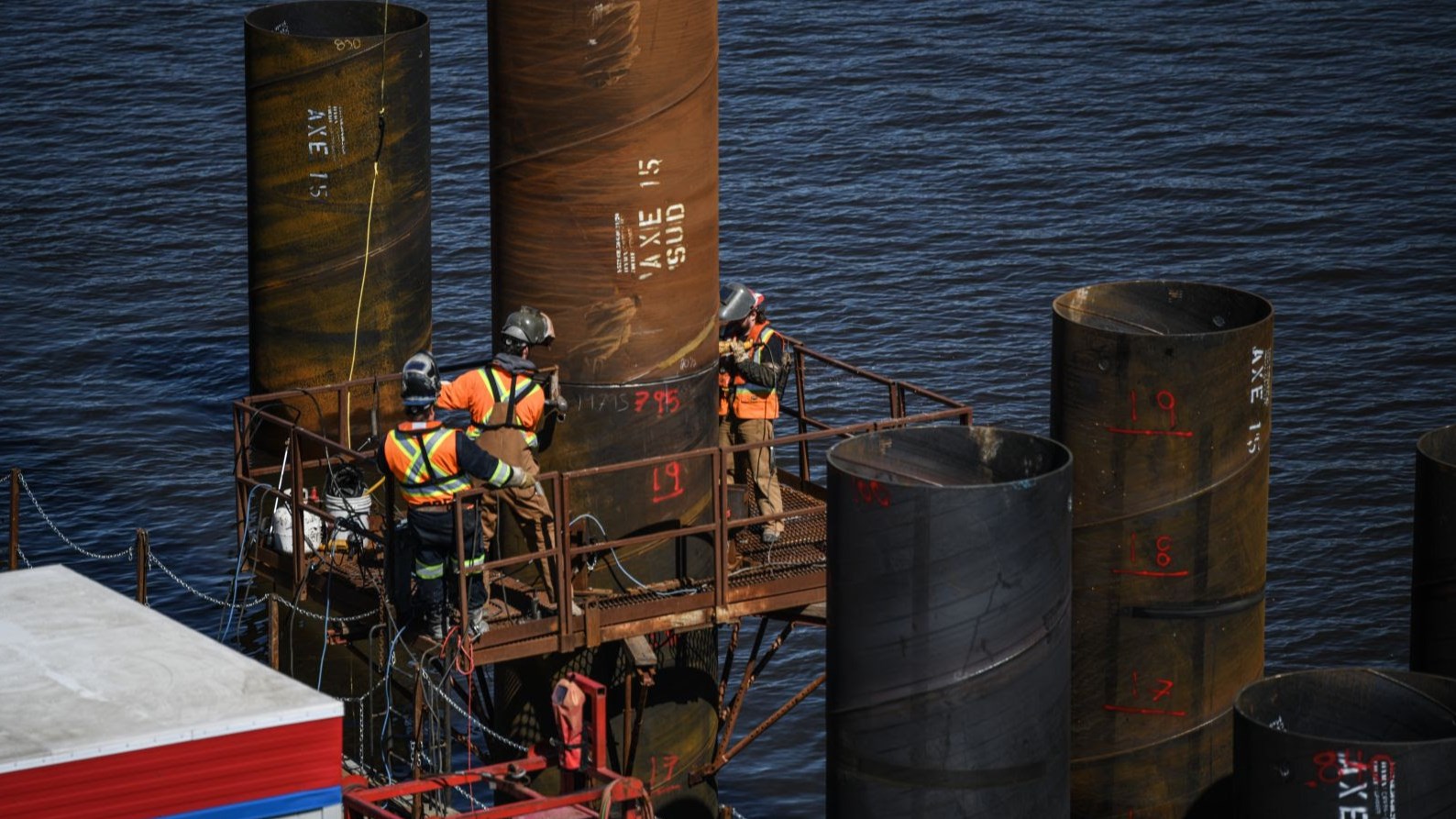 Des soudeurs à l’œuvre lors de l’installation des pieux en eau, mars 2024.