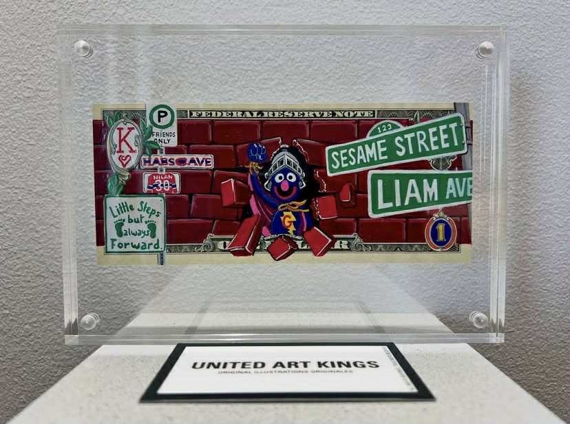 L’artiste United Art Kings a offert à Liam une œuvre d’art customisée : un billet de banque exclusif sur lequel on peut voir un personnage de Sesame Street.