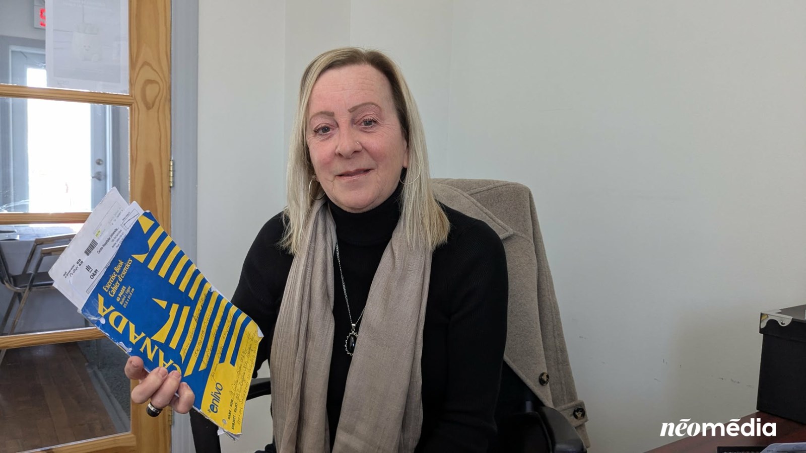 Anne St-Denis-Lalonde montre le cahier dans lequel elle inscrit toutes les informations médicales lors des rendez-vous médicaux des gens à qui elle vient en aide